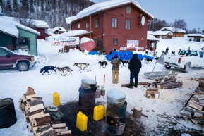 The view from the river bank in Takotna, Alaska as a sled dog team travels down the main street in town on March 11, 2020