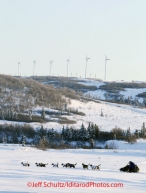 Sunday March 11, 2012  Rohn Buser runs on the slough leaving Unalakleet with wind turbines in the background. Iditarod 2012.