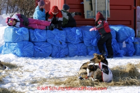 Sunday March 11, 2012  School children at Elim watch Aliy Zirkle 's dogs rest in the sun on straw.  Iditarod 2012