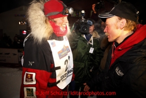 Aily Zirkle, left, greets with Iditarod winner Mitch Seavey after she pulled into Nome minutes after him on Tuesday March 12, 2013.Iditarod Sled Dog Race 2013Photo by Jeff Schultz copyright 2013 DO NOT REPRODUCE WITHOUT PERMISSION