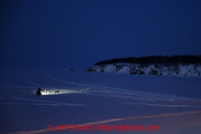 Pete Kaiser's headlamp shines on the Bering Sea shortly after leaving the Elim checkpoint on Tuesday March 12, 2013..Iditarod Sled Dog Race 2013Photo by Jeff Schultz copyright 2013 DO NOT REPRODUCE WITHOUT PERMISSION