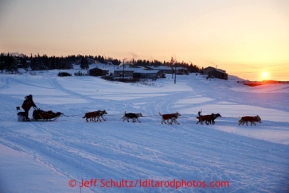 Paul Gebhart runs on a slough through the village of Elim on his way out of the checkpoint on Tuesday March 12, 2013.Iditarod Sled Dog Race 2013Photo by Jeff Schultz copyright 2013 DO NOT REPRODUCE WITHOUT PERMISSION