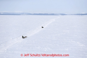 Cim Smyth and Jessie Royer run across Golovin Bay 12 miles before the White Mountain checkpoint on Tuesday March 12, 2013.Iditarod Sled Dog Race 2013Photo by Jeff Schultz copyright 2013 DO NOT REPRODUCE WITHOUT PERMISSION