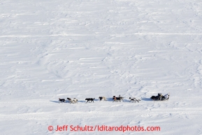 Martin Buser kicks back on his sled with his foot up as he travels over Golovin Bay on the way to the White Mountain checkpoint on Tuesday March 12, 2013.Iditarod Sled Dog Race 2013Photo by Jeff Schultz copyright 2013 DO NOT REPRODUCE WITHOUT PERMISSION