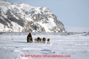 Cape Nome looms behind Mitch Seavey as he leads the race between White Mountain and Safety on Tuesday March 12, 2013.Iditarod Sled Dog Race 2013Photo by Jeff Schultz copyright 2013 DO NOT REPRODUCE WITHOUT PERMISSION