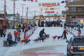 Michelle Philips gets help with getting her dog team into the finish chute at the Nome finish line on Front Street on  Wednesday March 12, during the 2014 Iditarod Sled Dog Race.PHOTO (c) BY JEFF SCHULTZ/IditarodPhotos.com -- REPRODUCTION PROHIBITED WITHOUT PERMISSION