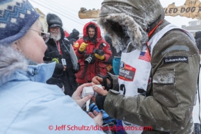 Robert Sorlie carried diptheria serum over the entire Iditarod trail and now presents it at the Nome finish line on Front Street  on Wednesday March 12, during the 2014 Iditarod Sled Dog Race.PHOTO (c) BY JEFF SCHULTZ/IditarodPhotos.com -- REPRODUCTION PROHIBITED WITHOUT PERMISSION