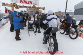 Ultra Sport bicyclists cross the finish line as Robert Sorlie and team check in at the Nome finish line on Front Street on Wednesday March 12, during the 2014 Iditarod Sled Dog Race.PHOTO (c) BY JEFF SCHULTZ/IditarodPhotos.com -- REPRODUCTION PROHIBITED WITHOUT PERMISSION