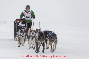 Katherine Keith runs on the sea ice within the Nome city limits on her way to the finish line on Thursday March 13 during the 2014 Iditarod Sled Dog Race.PHOTO (c) BY JEFF SCHULTZ/IditarodPhotos.com -- REPRODUCTION PROHIBITED WITHOUT PERMISSION