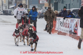 Jason Mackey finished the Iditarod with his son Patrick on the sled inside the finish chute at Nome on Thursday March 13 during the 2014 Iditarod Sled Dog Race.PHOTO (c) BY JEFF SCHULTZ/IditarodPhotos.com -- REPRODUCTION PROHIBITED WITHOUT PERMISSION