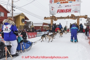 Karin Hendrickson runs under the burl arch finish line in Nome on Thursday March 13 during the 2014 Iditarod Sled Dog Race.PHOTO (c) BY JEFF SCHULTZ/IditarodPhotos.com -- REPRODUCTION PROHIBITED WITHOUT PERMISSION