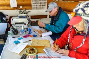 Volunteer Comms Jim Johnson and team work the comms table inside the community center in Ruby on Thursday March 12, 2015 during Iditarod 2015.(C) Jeff Schultz/SchultzPhoto.com - ALL RIGHTS RESERVED DUPLICATION  PROHIBITED  WITHOUT  PERMISSION