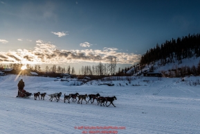 Anna Berington runs down the Yukon River as she leaves the Ruby Checkpoint at sunrise on Saturday March 12th during the 2016 Iditarod.  Alaska    Photo by Jeff Schultz (C) 2016  ALL RIGHTS RESERVED