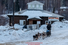 Kristy Berington runs past the Community Hall as she leaves the Ruby Checkpoint in the morning on Saturday March 12th during the 2016 Iditarod.  Alaska    Photo by Jeff Schultz (C) 2016  ALL RIGHTS RESERVED