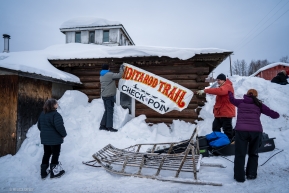 Volunteers hang the checkpoint sign on the community hall in Ruby, Alaska.