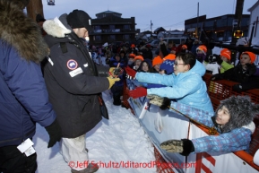 Tuesday March 13, 2012   Third place finisher Ramey Smyth gives dog booties to kids at the finish line in Nome.  Iditarod 2012.