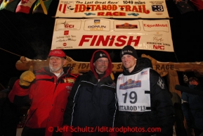 Three generations of Seavey's Dan, Mitch and Dallas pose at the finish line in Nome shorlty after Dallas crossed the finish line in 4th place on Wednesday March 13, 2013. Iditarod Sled Dog Race 2013Photo by Jeff Schultz copyright 2013 DO NOT REPRODUCE WITHOUT PERMISSION