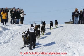 Brent Sass is welcomed to Nome by race fans as he runs up the seawall ramp from the Bering Sea onto Nome's Front Street less than a mile from the finish line in Nome on Wednesday March 13, 2013. Iditarod Sled Dog Race 2013Photo by Jeff Schultz copyright 2013 DO NOT REPRODUCE WITHOUT PERMISSION