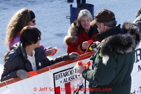 Iditarod fan Lynden Pendleton passes out used booties from Michelle Phillips dogs to spectators at the finish chute in Nome on Wednesday March 13, 2013. Iditarod Sled Dog Race 2013Photo by Jeff Schultz copyright 2013 DO NOT REPRODUCE WITHOUT PERMISSION