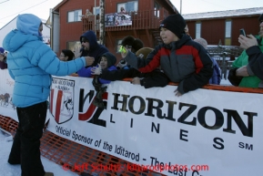 Aviva Beringhouse of Rhode Island passes out Brent Sass booties at the finish line in Nome on Wednesday March 13, 2013. Iditarod Sled Dog Race 2013Photo by Jeff Schultz copyright 2013 DO NOT REPRODUCE WITHOUT PERMISSION