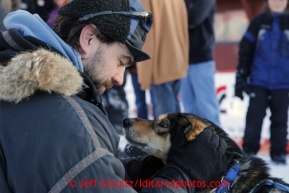 Tom Lesatz gives Jessica Hendricks lead dog Bruno some attention in the finish chute after Jessica finished the race on Wednesday March 13, 2013. Iditarod Sled Dog Race 2013Photo by Jeff Schultz copyright 2013 DO NOT REPRODUCE WITHOUT PERMISSION