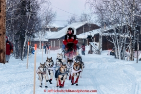 Aliy Zirkle runs down the road in the evening on her way through the Huslia checkpoint on Friday March 13, 2015 during Iditarod 2015.  (C) Jeff Schultz/SchultzPhoto.com - ALL RIGHTS RESERVED DUPLICATION  PROHIBITED  WITHOUT  PERMISSION