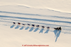 A team casts long shadows on teh Yukon River as he heads toward the Galena checkpoint on Friday March 13, 2015 during Iditarod 2015.  (C) Jeff Schultz/SchultzPhoto.com - ALL RIGHTS RESERVED DUPLICATION  PROHIBITED  WITHOUT  PERMISSION