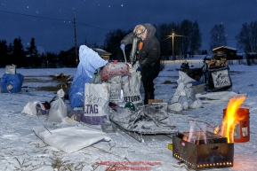 Lars Monsen prepares to cook dog food in the early morning at the Kaltag checkpoint on Sunday March 13th during the 2016 Iditarod.  Alaska    Photo by Jeff Schultz (C) 2016  ALL RIGHTS RESERVED