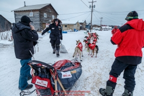 Ed Stielstra brings his food bag to his sled as he checks in and out of  the Kaltag checkpoint on Sunday morning March 13th during the 2016 Iditarod.  Alaska    Photo by Jeff Schultz (C) 2016  ALL RIGHTS RESERVED