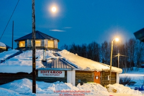 A full moon is in the sky over the community center at the Kaltag checkpoint during the 2017 Iditarod on Monday morning March 12, 2017.Photo by Jeff Schultz/SchultzPhoto.com  (C) 2017  ALL RIGHTS RESERVED