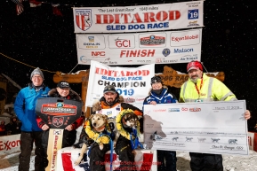 Pete Kaiser sits with his lead dogs Marrow (L) and Lucy and the principal sponsors at the Nome finish line after winning the 2019 Iditarod Trail Sled Dog Race. Pete's winning time is 9 days 12 hours 39 minutes and 6 secondsPhoto by Jeff Schultz/  (C) 2019  ALL RIGHTS RESERVED