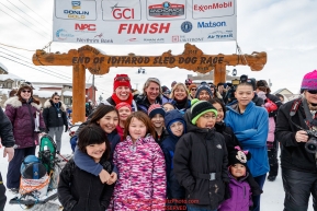 Aliy Zirkle poses with a group of students at the finish line in Nome shortly after finishing the 2019 Iditarod in 4th place on Wednesday March 13Photo by Jeff Schultz/  (C) 2019  ALL RIGHTS RESERVED