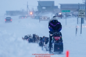Jessie Royer runs down Front Street with a police escort in a wind-storm as she makes her way toward the Nome finish line to place 3rd in the 2019 Iditarod sled dog race.Photo by Jeff Schultz/  (C) 2019  ALL RIGHTS RESERVED