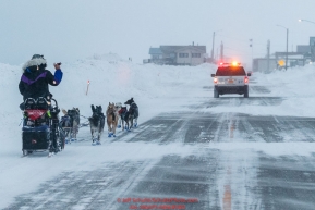 Jessie Royer runs down Front Street with a police car escort as she makes her way toward the Nome finish line to place 3rd in the 2019 Iditarod sled dog race.Photo by Jeff Schultz/  (C) 2019  ALL RIGHTS RESERVED