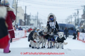 Kristi Berington runs into the chute toward the burl arch finish line in Nome on Thursday March 13 during the 2014 Iditarod Sled Dog Race.PHOTO (c) BY JEFF SCHULTZ/IditarodPhotos.com -- REPRODUCTION PROHIBITED WITHOUT PERMISSION