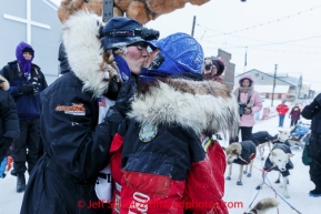 Kristi Berington gets a kiss from Paul Gebhart shortly after she crossed the burl arch finish line in Nome on Thursday March 13 during the 2014 Iditarod Sled Dog Race.PHOTO (c) BY JEFF SCHULTZ/IditarodPhotos.com -- REPRODUCTION PROHIBITED WITHOUT PERMISSION