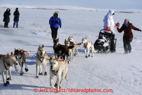 Justin Savidas gets a soda handed to him as he crosses the Nome road about 4 miles from the finish line in 30 mph winds on Thursday March 14, 2013 during the Iditarod Sled Dog Race 2013Photo by Jeff Schultz copyright 2013 DO NOT REPRODUCE WITHOUT PERMISSION