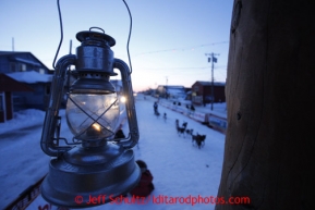 The Widows Lamp, lit until the last musher reaches Nome hangs from the burled finish line arch in as Paige Drobny runs down the finish line in 34th place on Thursday March 14, 2013. Iditarod Sled Dog Race 2013Photo by Jeff Schultz copyright 2013 DO NOT REPRODUCE WITHOUT PERMISSION