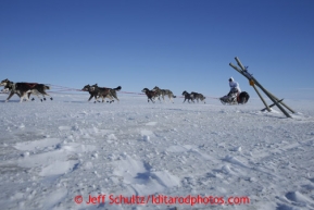 Travis Beals runs past a parlty blown over tripod on the trail a few miles from Nome in 30 mph winds on Thursday March 14, 2013 during the Iditarod Sled Dog Race 2013Photo by Jeff Schultz copyright 2013 DO NOT REPRODUCE WITHOUT PERMISSION