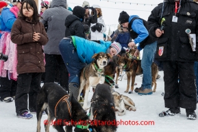 A crowd gathers around Newton Marshall and team in the finish chute after he arrived in 43rd place in Nome on Friday March 14 during the 2014 Iditarod Sled Dog Race.PHOTO (c) BY JEFF SCHULTZ/IditarodPhotos.com -- REPRODUCTION PROHIBITED WITHOUT PERMISSION