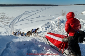 Travis Beals team drops down the bank onto the Koyukuk River in the afternoon after leaving the Huslia checkpoint on Saturday  March 14, 2015 during Iditarod 2015.  (C) Jeff Schultz/SchultzPhoto.com - ALL RIGHTS RESERVED DUPLICATION  PROHIBITED  WITHOUT  PERMISSION