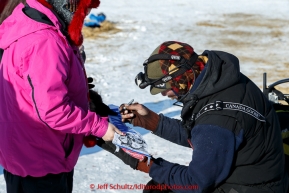 Lance Mackey signs an autograph for a young race fan in the afternoon at the Huslia checkpoint on Saturday  March 14, 2015 during Iditarod 2015.  (C) Jeff Schultz/SchultzPhoto.com - ALL RIGHTS RESERVED DUPLICATION  PROHIBITED  WITHOUT  PERMISSION