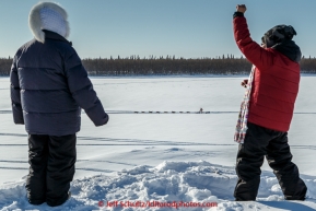 Huslia residents cheer on departing teams from the bank of the Koyukuk river in the afternoon at the Huslia checkpoint on Saturday  March 14, 2015 during Iditarod 2015.  (C) Jeff Schultz/SchultzPhoto.com - ALL RIGHTS RESERVED DUPLICATION  PROHIBITED  WITHOUT  PERMISSION