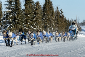 Tim Hunt runs down the road on his way into the Huslia checkpoint in the evening on Saturday March 14, 2015 during Iditarod 2015.  (C) Jeff Schultz/SchultzPhoto.com - ALL RIGHTS RESERVED DUPLICATION  PROHIBITED  WITHOUT  PERMISSION