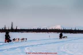 Lev Shvarts and Marcelle Fressineau run on the trail few miles before the Huslia checkpoint with the Brooks Range in the background Saturday  March 14, 2015 during Iditarod 2015.  (C) Jeff Schultz/SchultzPhoto.com - ALL RIGHTS RESERVED DUPLICATION  PROHIBITED  WITHOUT  PERMISSION