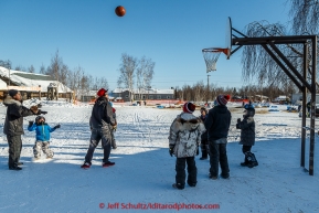 Huslia students play basketball outside as dogs rest in the ballfield behind them at the Huslia checkpoint on Saturday  March 14, 2015 during Iditarod 2015.  (C) Jeff Schultz/SchultzPhoto.com - ALL RIGHTS RESERVED DUPLICATION  PROHIBITED  WITHOUT  PERMISSION