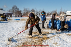 Huslia residents volunteer to rake used straw in the afternoon at the Huslia checkpoint on Saturday  March 14, 2015 during Iditarod 2015.  (C) Jeff Schultz/SchultzPhoto.com - ALL RIGHTS RESERVED DUPLICATION  PROHIBITED  WITHOUT  PERMISSION