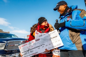 ExxonMobil representative Corey Hines presents Mitch Seavey with his 75,000 winner's purse check after Mitch won his third Iditarod in record time of 8 days, 3 hours, 40 minutes and 13 seconds in Nome during the 2017 Iditarod on Tuesday afternoon March 14, 2017.Photo by Jeff Schultz/SchultzPhoto.com  (C) 2017  ALL RIGHTS RESERVED