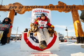 Mitch Seavey poses with his lead dogs Pilot and Crisp on the winner's stand after winning his third Iditarod in record time of 8 days, 3 hours, 40 minutes and 13 seconds in Nome during the 2017 Iditarod on Tuesday afternoon March 14, 2017.Photo by Jeff Schultz/SchultzPhoto.com  (C) 2017  ALL RIGHTS RESERVED