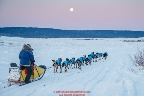 Hans Gatt runs on the sea ice of Norton Sound after leaving the Koyuk checkpoint with a full  moon setting during the 2017 Iditarod on Tuesday morning March 12, 2017.Photo by Jeff Schultz/SchultzPhoto.com  (C) 2017  ALL RIGHTS RESERVED